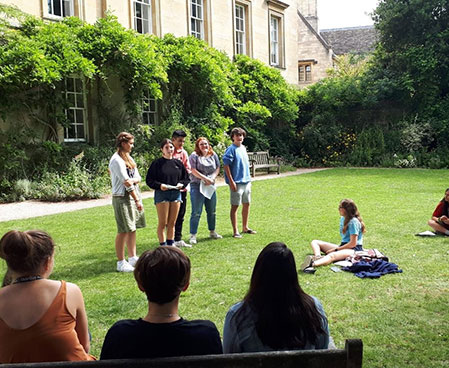 students relax on the grass during a sunny day in oxford